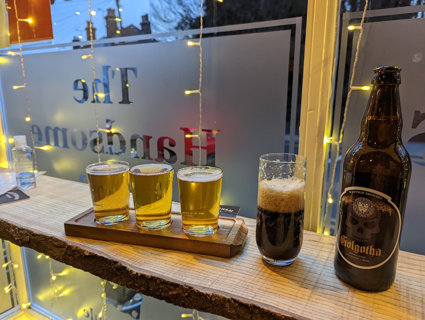 A flight of beers and bottles on the window ledge